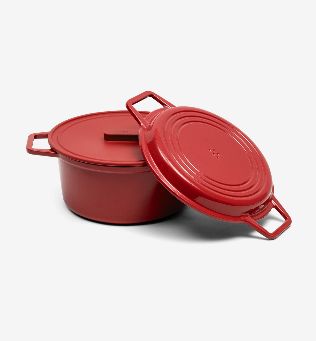 Red enameled cast iron Dutch oven with lid resting against pot